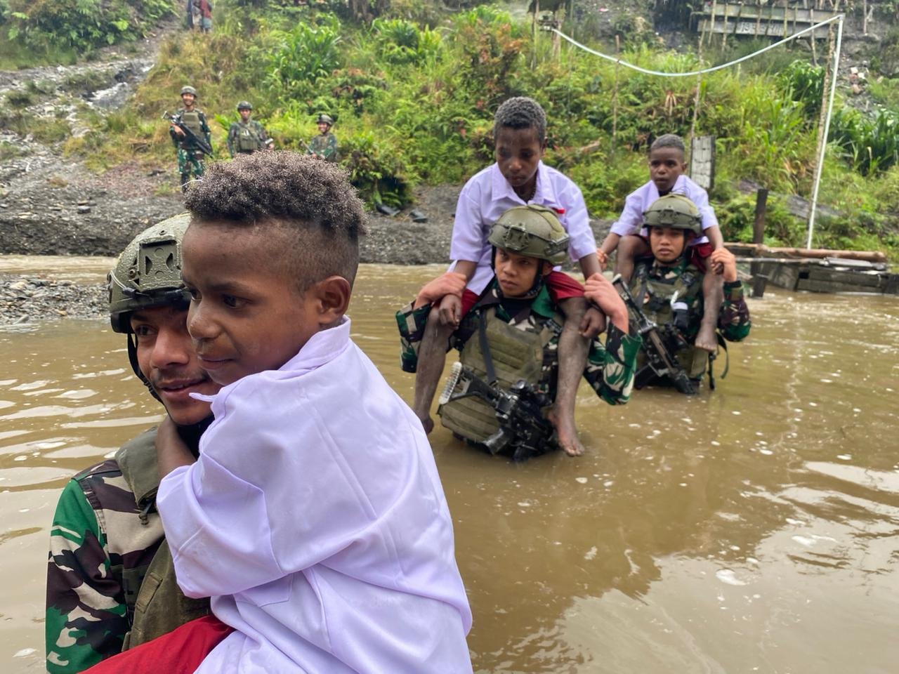 Satgas TNI Bantu Anak-Anak Kampung Dal Seberangi Sungai Berangkat Ke Sekolah
