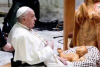 Paus Fransiskus didepan bayi Yesus 